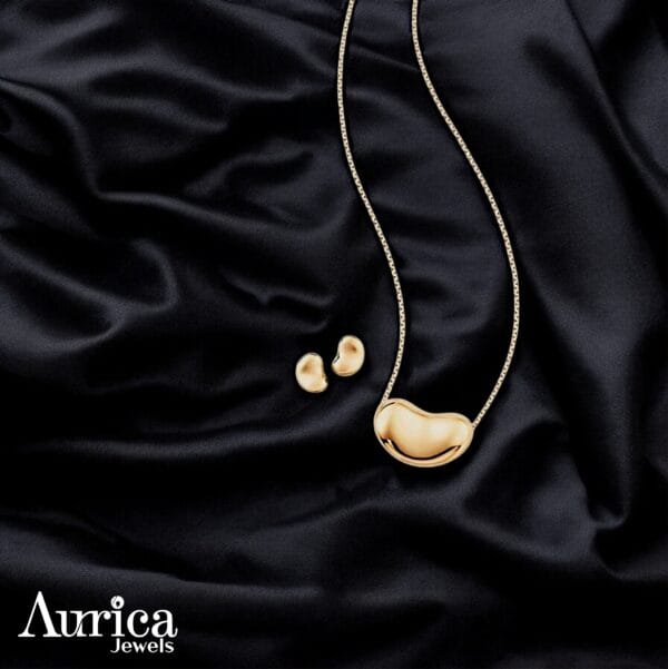 The Golden Bean Metallic Pendant is a perfect combination of simplicity and modern elegance. With its unique bean-inspired design, this jewellery set exudes sophistication while maintaining a minimalist appeal. Crafted with a glossy golden finish, it’s an ideal accessory to add charm to any look.