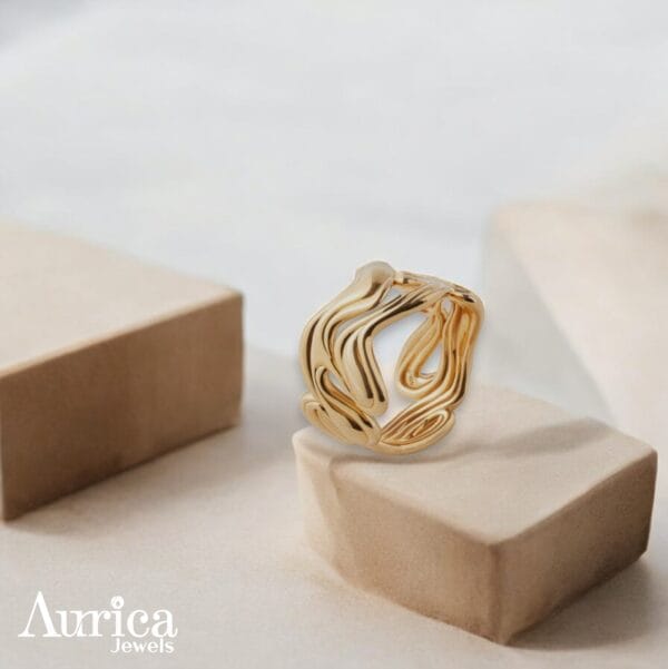 The Fluid Elegance Ring embodies contemporary artistry with a design inspired by the graceful flow of liquid metallic gold colour.